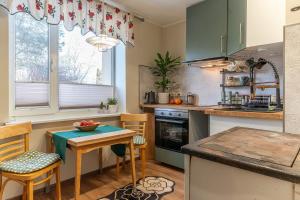 a kitchen with green cabinets and a table and chairs at One bedroom apartment in Viljandi