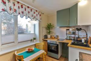 a kitchen with green cabinets and a table and a sink at One bedroom apartment in Viljandi +8 photos