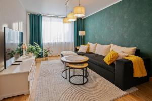 a living room with a black couch and a table at One bedroom apartment in Viljandi