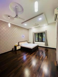 a large bedroom with a bed and a wooden floor at solomons ark luxury pool villa in Cochin