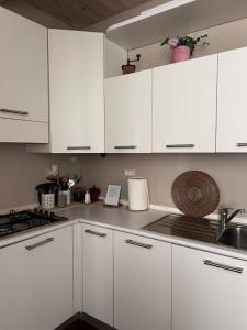 a white kitchen with white cabinets and a sink at Martina Fillungo Loft in Lucca +16 photos