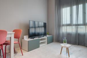 a living room with a tv and a table and chairs at Lux Sevilla Apartment Piscina in Bormujos