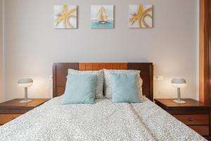 a bedroom with a large bed with blue pillows at Lux Sevilla Apartment Piscina in Bormujos