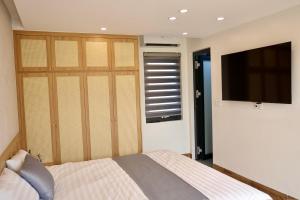 a bedroom with a bed and a flat screen tv at The C'mon Mộc Châu in Làng Môn