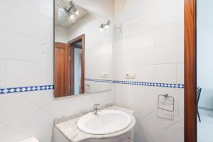 a white bathroom with a sink and a mirror at Lux Sevilla Apartment Piscina in Bormujos +62 photos