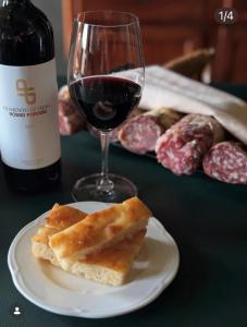 a glass of wine and a plate with a piece of bread at Locanda Orticello in Monferrato in Cremolino +16 photos