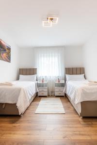 two beds in a white room with a window at Next Lap - Rooms in Quiddelbach