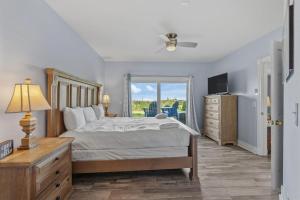 a bedroom with a bed and a television and a window at Wicked Fun at Windswept Ridge in Corolla +48 photos
