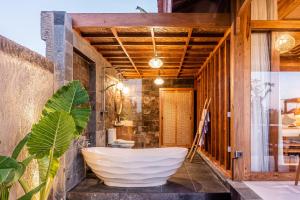 a bathroom with a large white bath tub in a room at Kubu Tama Villa in Tegalalang +34 photos
