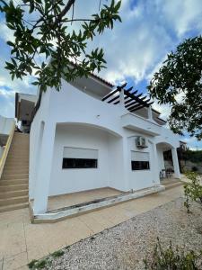 a white house with a staircase in front at Large 2 bedroom Lagos apartment in Lagos