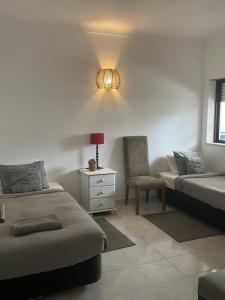 a bedroom with two beds and a chair and a lamp at Large 2 bedroom Lagos apartment in Lagos +3 photos