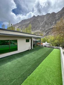 a house with a large yard with green grass at Pak Himalaya Hotel Kachura in Ponedas