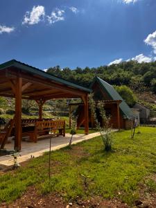 a wooden pavilion with a picnic table in a field at AI Cottage in Virpazar