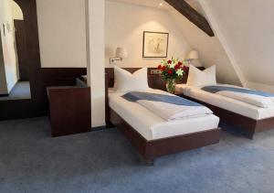 two beds in a room with flowers in the middle at Hotel Goldener Adler in Bautzen +37 photos