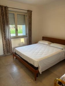 a bed in a bedroom with a large window at L'imbarco ROOMS in Badolato Stazione +11 photos