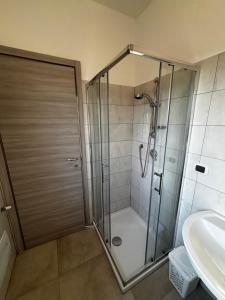 a shower with a glass door in a bathroom at L'imbarco ROOMS in Badolato Stazione