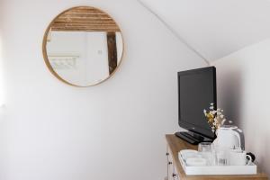 a mirror on top of a table with a tv at The Ash Tree in Ashendon