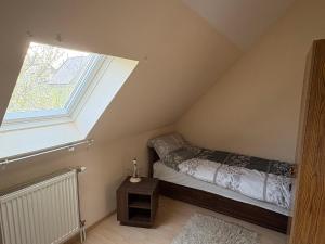 a bedroom with a bed and a window at Valéria Vendégház in Budakalász