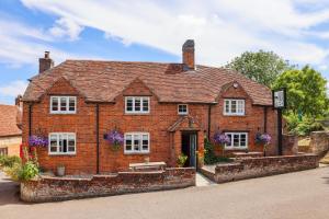 a red brick house with a clock on it at The Ash Tree in Ashendon