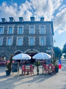 a group of chairs and umbrellas in front of a building at L Annexe d Aubrac in Aubrac