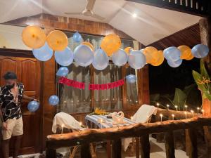 a man standing in front of a table with balloons at Havelock Farms Resort in Havelock Island