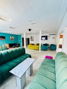 a living room with green couches and a table at La Castrol Hotel Apartments in Limbe