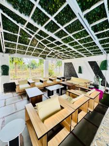a dining room with tables and chairs and plants at La Castrol Hotel Apartments in Limbe