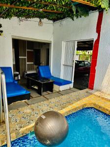 a pool with blue chairs and a table and a ball at La Castrol Hotel Apartments in Limbe
