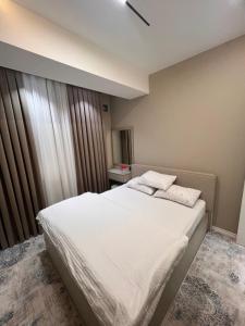 a bedroom with a bed with white sheets and pillows at Rakhim bobo 2 in Bukhara