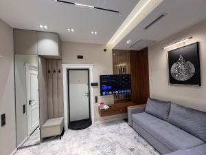 a living room with a couch and a flat screen tv at Rakhim bobo 2 in Bukhara