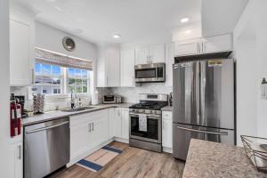 a kitchen with white cabinets and stainless steel appliances at Coffee | Streaming TV | Fast WIFI | Pet Friendly in Seaside Heights