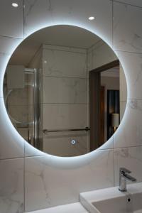 a bathroom mirror with a sink and a shower at Beaufort Hotel in Inverness +249 photos