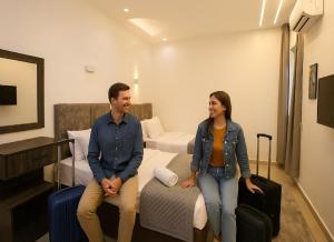 a man and woman standing in a hotel room with luggage at Karma Cairo Hotel in Cairo