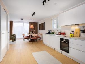 a kitchen with white cabinets and a dining room at PLEIB COLOGNE - Premium Suites in Cologne