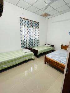 two beds sitting in a room with water on the floor at Pudam Cottege in Kataragama +6 photos