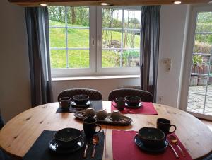 a wooden table with bowls and cups on top of it at Ferienwohnung am Waldrand in Kalletal