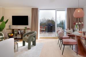 a living room with a table and chairs and a television at PLEIB COLOGNE - Premium Suites in Cologne