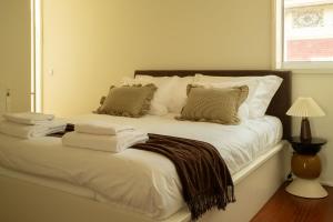 a white bed with pillows and a blanket on it at Casanova Seaside in Porto