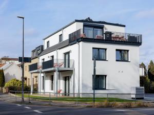 a white building with a balcony on top of it at PLEIB COLOGNE - Premium Suites in Cologne