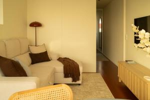 a living room with a couch and a tv at Casanova Seaside in Porto