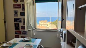 a room with a table and a view of the ocean at WELCOME - Scilla Casa Vacanze in Scilla