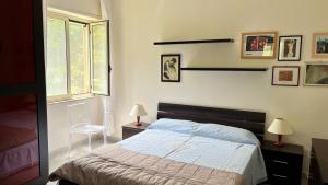 a bedroom with a bed and a window and a chair at WELCOME - Scilla Casa Vacanze in Scilla