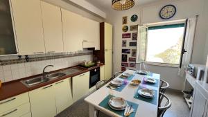 a kitchen with a table and a sink and a window at WELCOME - Scilla Casa Vacanze in Scilla