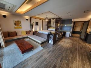 a living room with a couch and a table at Jeju Its Hill Pension in Jeju +9 photos