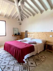 a bedroom with a large bed with a red blanket at Podere Castellare in Pelago