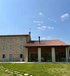 a large stone building with a red roof at Agriturismo Rive De Guia in Valdobbiadene