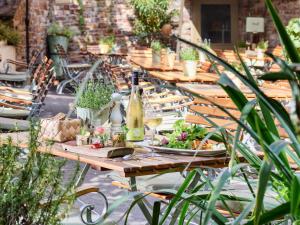 a long wooden table with plants and bottles of wine at Hotel Zeltinger-Hof - Gasthaus des Rieslings in Zeltingen-Rachtig
