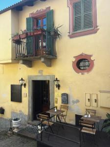 a building with tables and chairs and a balcony at Locanda Orticello in Monferrato in Cremolino