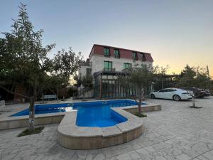 a swimming pool in front of a building with a car at Villa Loft in Balaovit