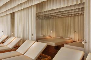 a living room with white chairs and tables at ElzLand Hotel Pfauen WELLNESS & SPA in Elzach